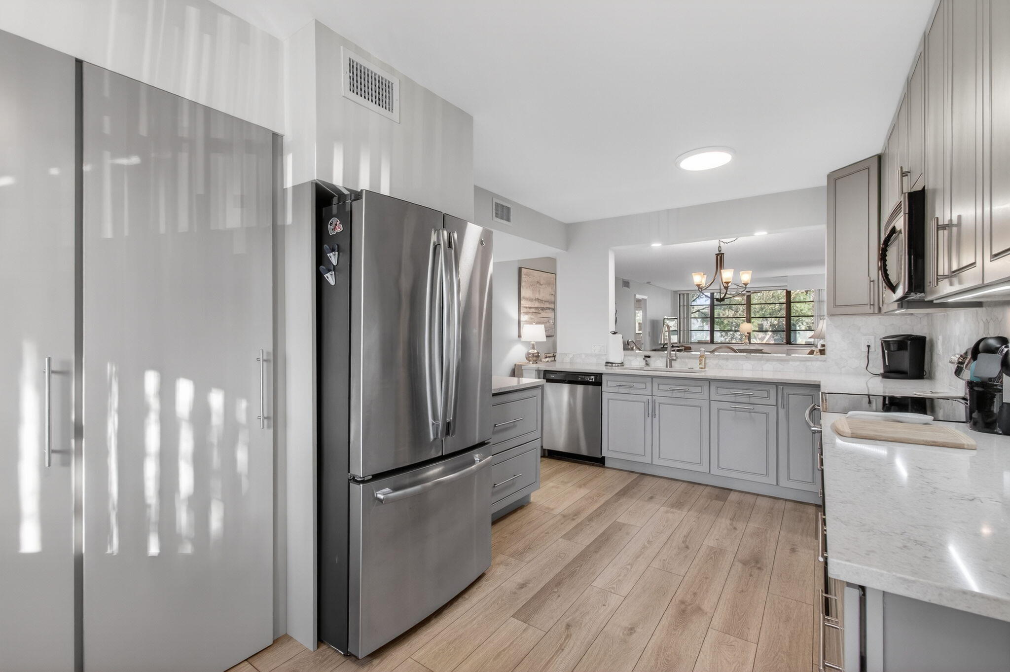15074 Witney Road, Unit 204 Delray Beach, FL 33484 - Photo 24 of 56 a kitchen with stainless steel appliances a refrigerator a sink cabinets and wooden floor