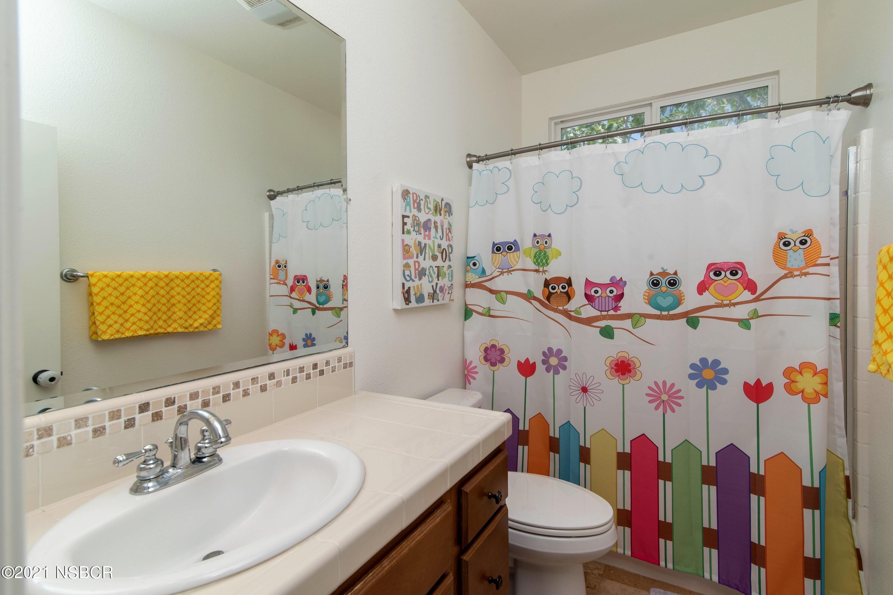 3709 Jupiter Avenue Lompoc, CA 93436 - Photo 17 of 26 a bathroom with a sink a toilet and a shower curtain