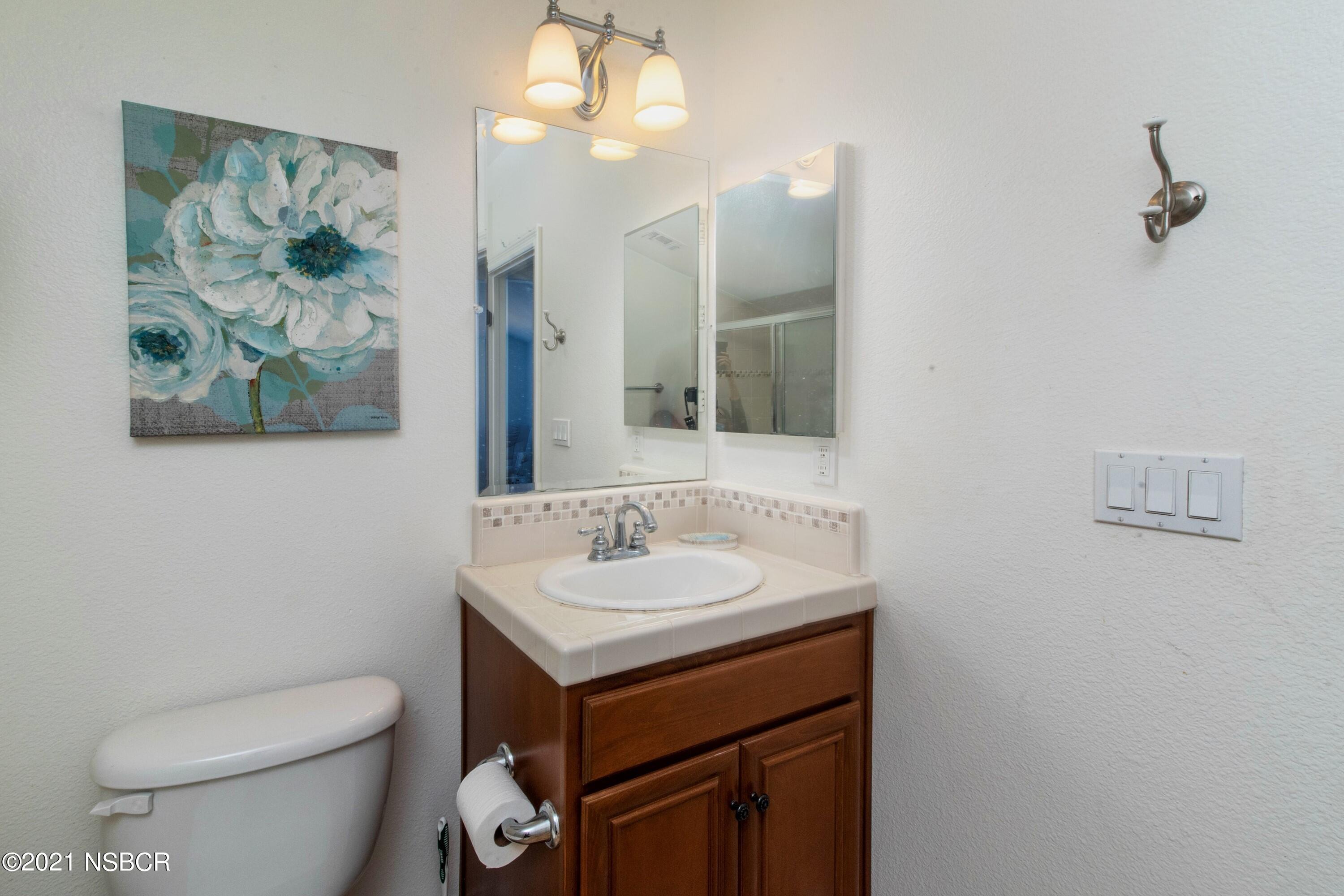 3709 Jupiter Avenue Lompoc, CA 93436 - Photo 22 of 26 a bathroom with a toilet a sink and mirror
