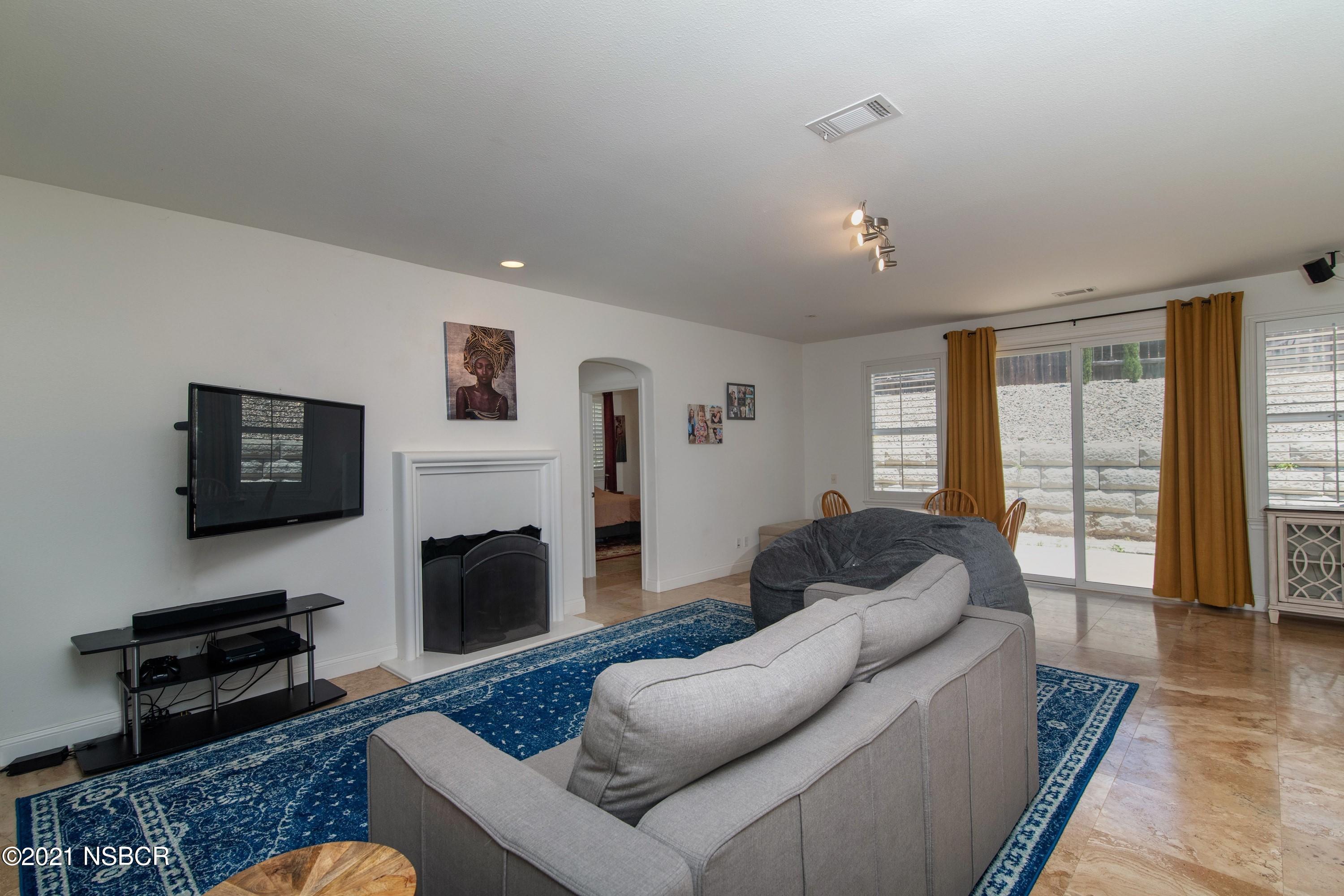 3709 Jupiter Avenue Lompoc, CA 93436 - Photo 9 of 26 a living room with furniture flat screen tv and a fireplace