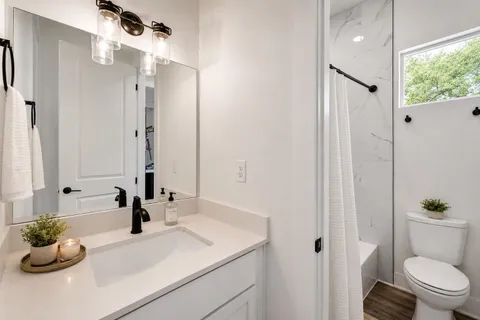 a bathroom with a sink a toilet and a mirror