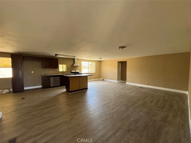 a kitchen with stainless steel appliances kitchen island granite countertop a large counter top and wooden floors