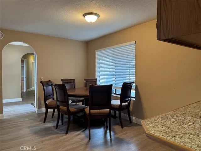 a kitchen with stainless steel appliances kitchen island granite countertop a sink a stove a table and chairs