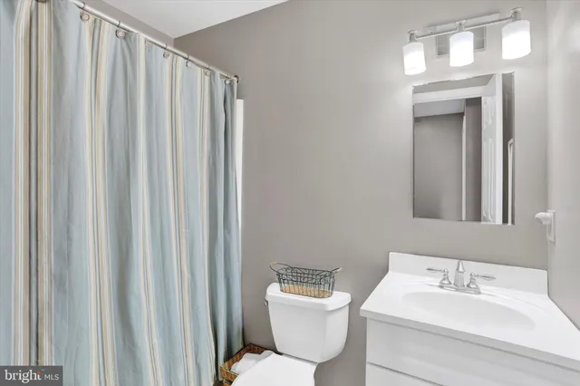 a bathroom with a toilet a sink and a mirror