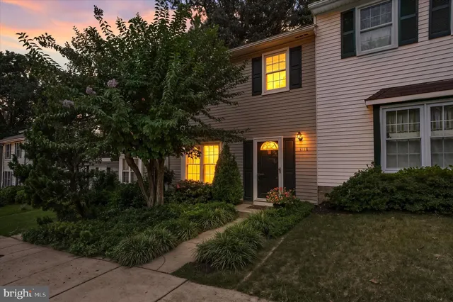 a view of a house with brick walls and a yard with plants