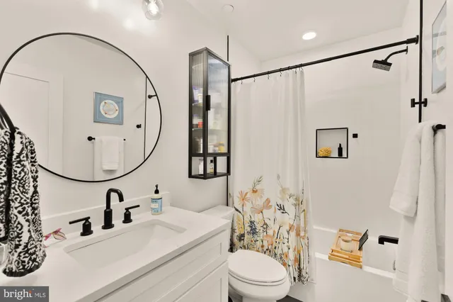 a bathroom with a sink vanity mirror and toilet