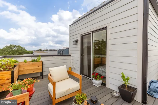 an outdoor living room with patio furniture and a garden