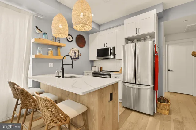 a kitchen with stainless steel appliances granite countertop a sink a stove and a refrigerator