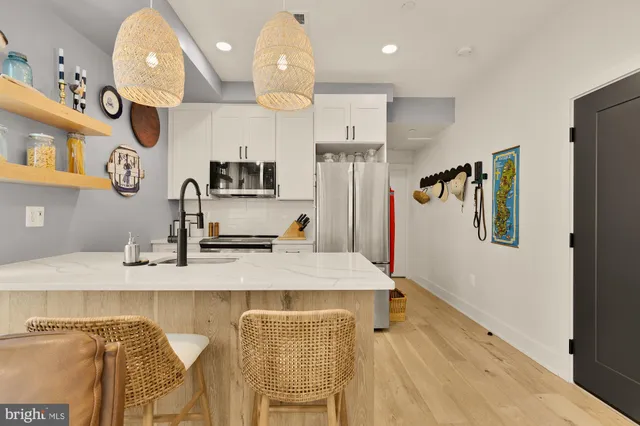 a kitchen with stainless steel appliances kitchen island granite countertop a refrigerator and a sink
