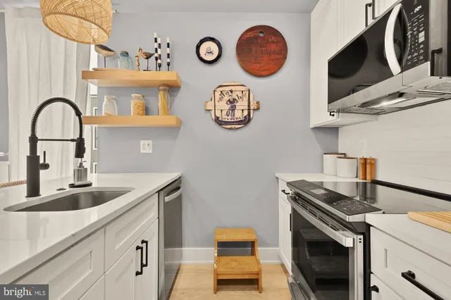 a kitchen with stainless steel appliances granite countertop a sink and a stove