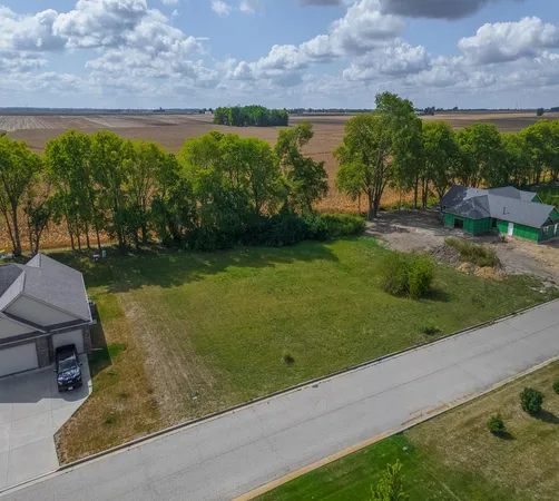 an aerial view of residential houses with outdoor space and trees