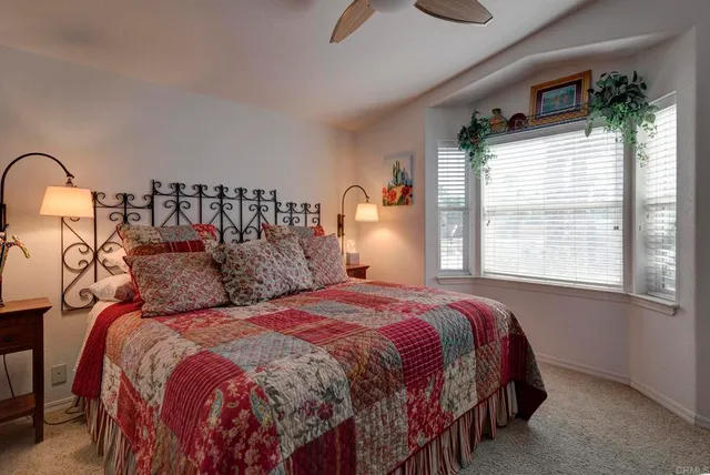 a bedroom with a bed a mirror and a large window