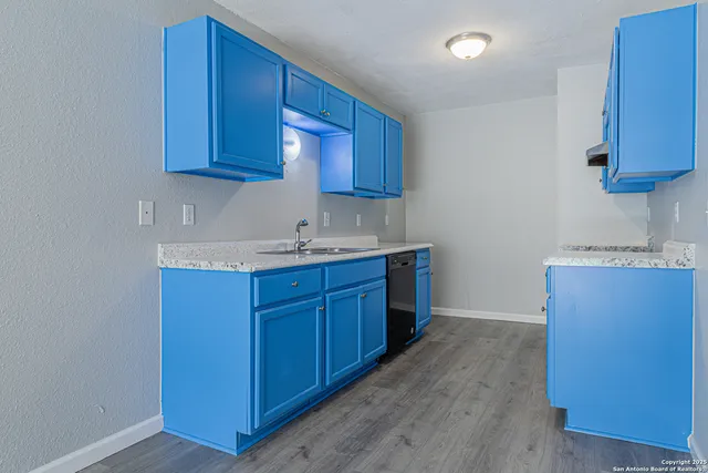 a kitchen with granite countertop wooden cabinets and a sink