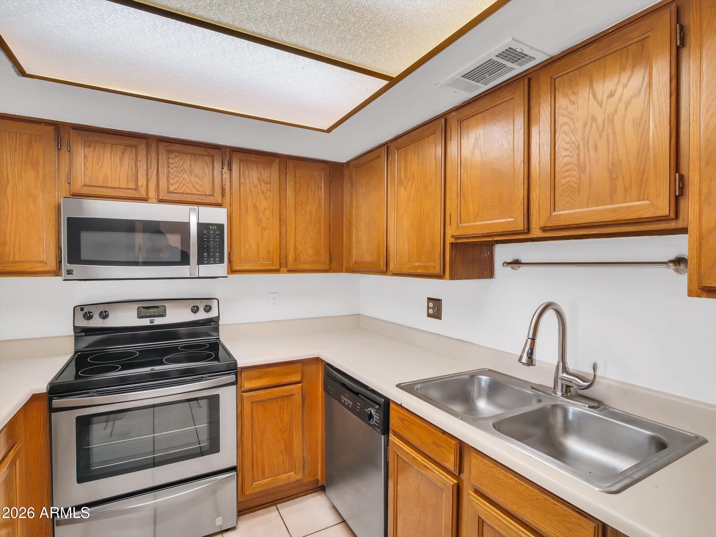 1645 West Baseline Road, Unit 2072 Mesa, AZ 85202 - Photo 12 of 37 a kitchen with a sink stove and microwave