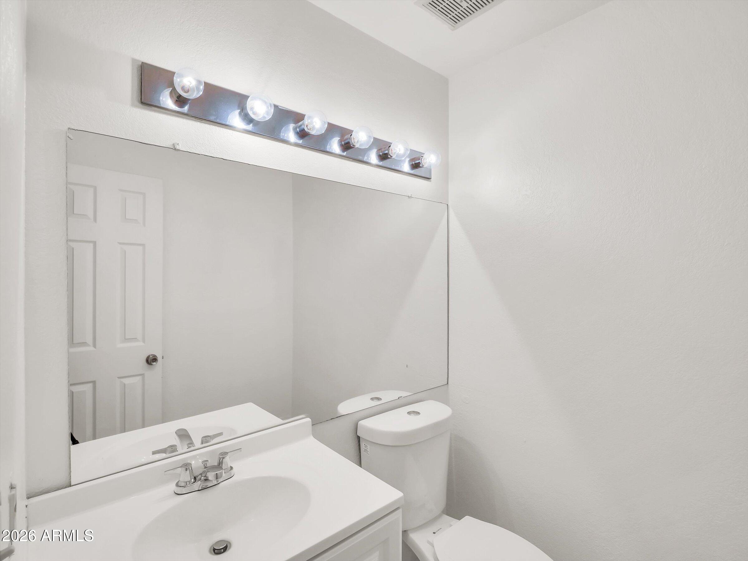 1645 West Baseline Road, Unit 2072 Mesa, AZ 85202 - Photo 16 of 37 a bathroom with a sink a toilet and mirror