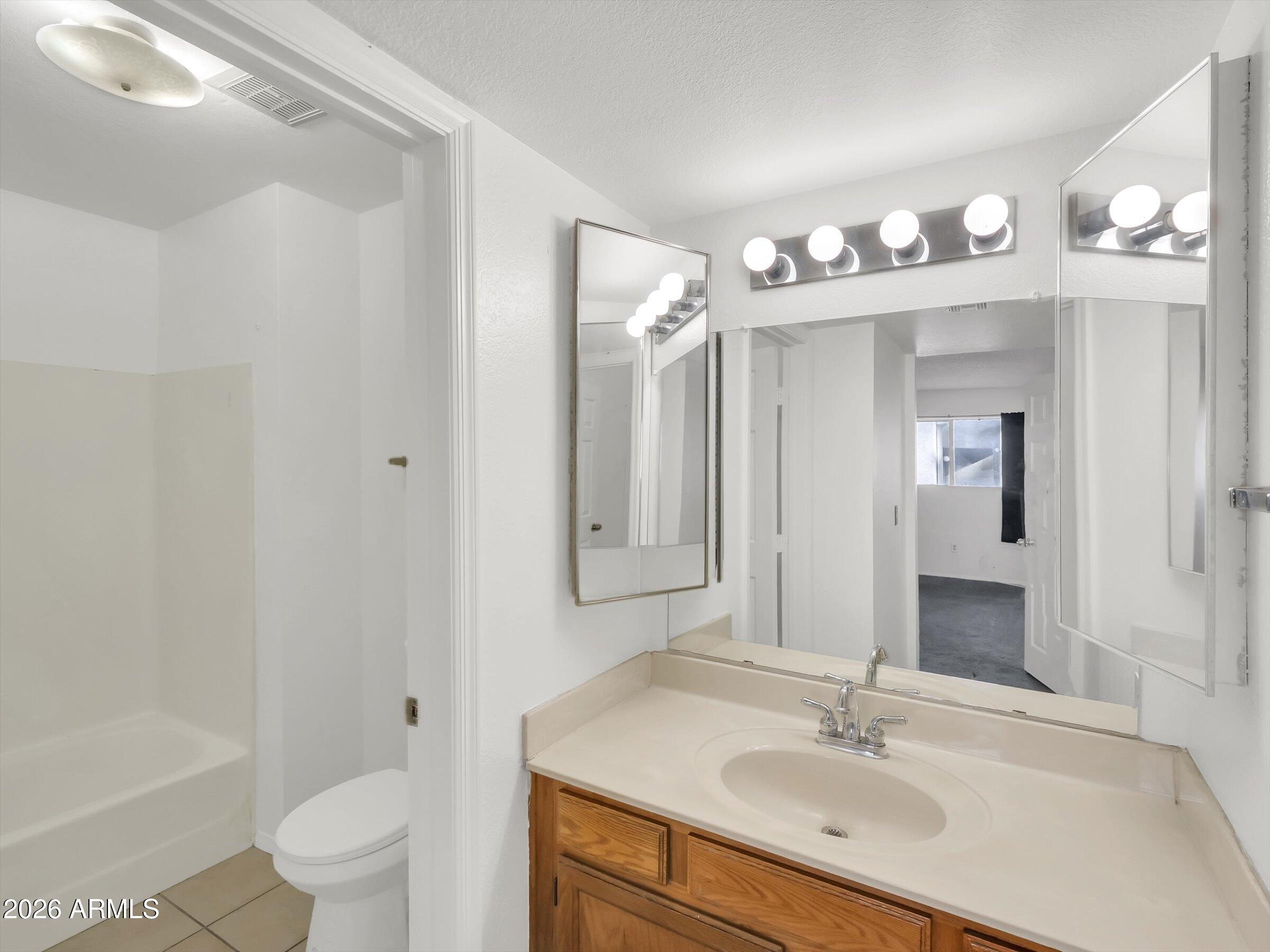 1645 West Baseline Road, Unit 2072 Mesa, AZ 85202 - Photo 30 of 37 a bathroom with a sink a toilet a mirror and shower