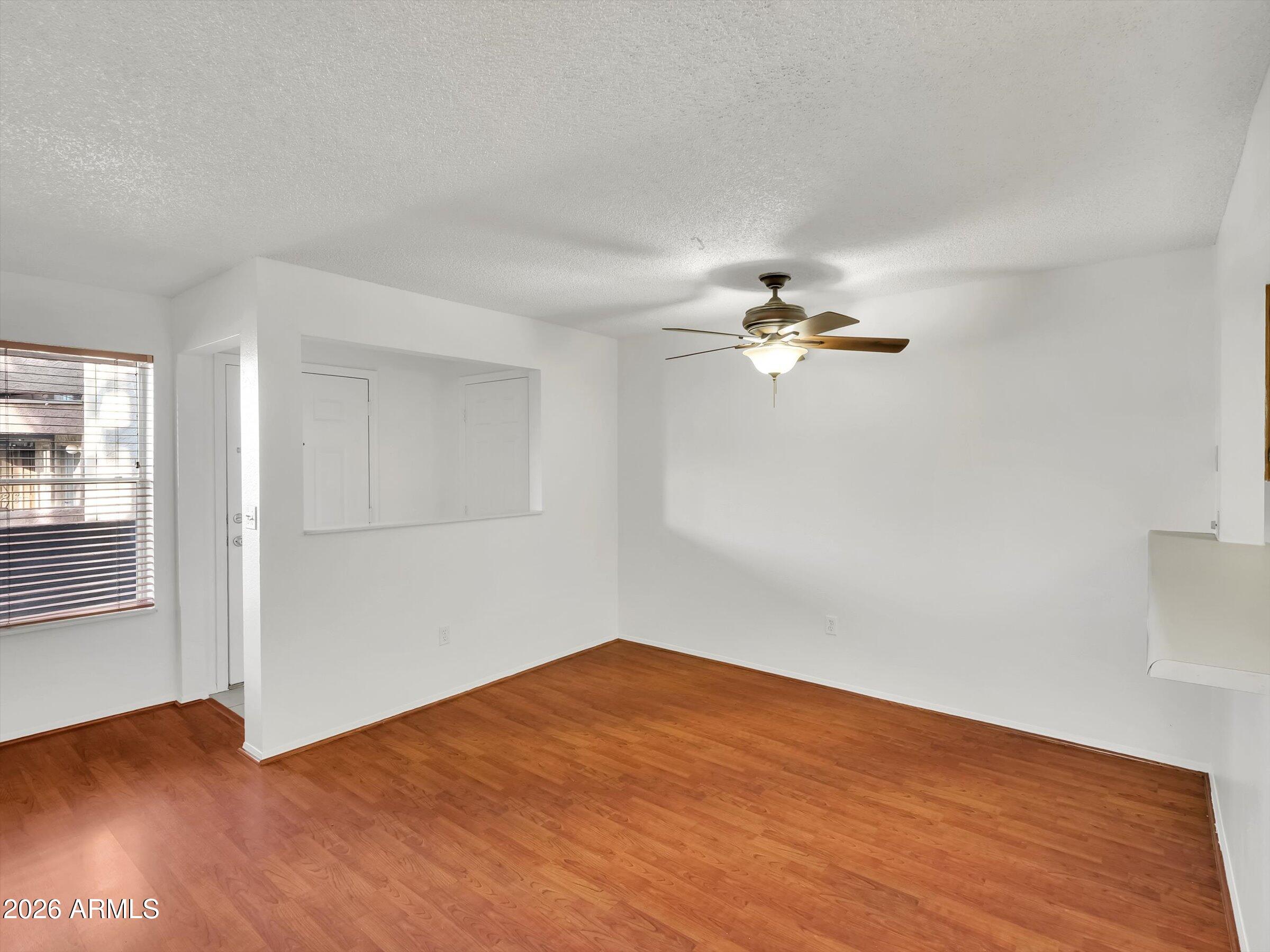1645 West Baseline Road, Unit 2072 Mesa, AZ 85202 - Photo 9 of 37 a view of empty room with wooden floor and fan