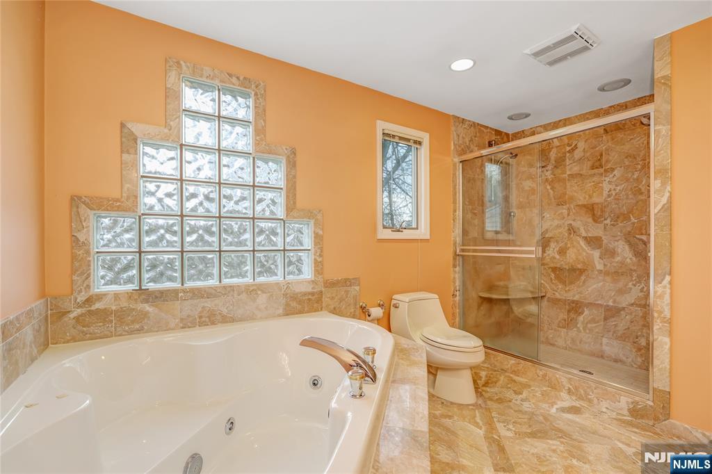 31 Collins Avenue Closter, NJ 07624 - Photo 18 of 37 a bathroom with a bathtub and a shower