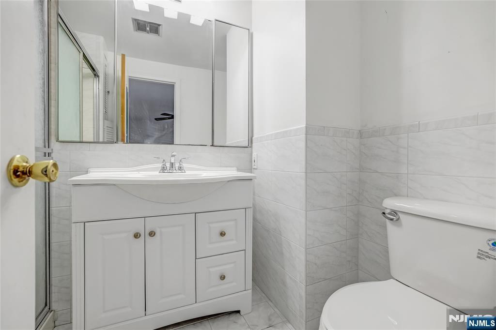 31 Collins Avenue Closter, NJ 07624 - Photo 23 of 37 a bathroom with a sink toilet and mirror