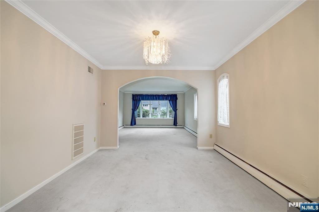 31 Collins Avenue Closter, NJ 07624 - Photo 6 of 37 an empty room with a fireplace and windows