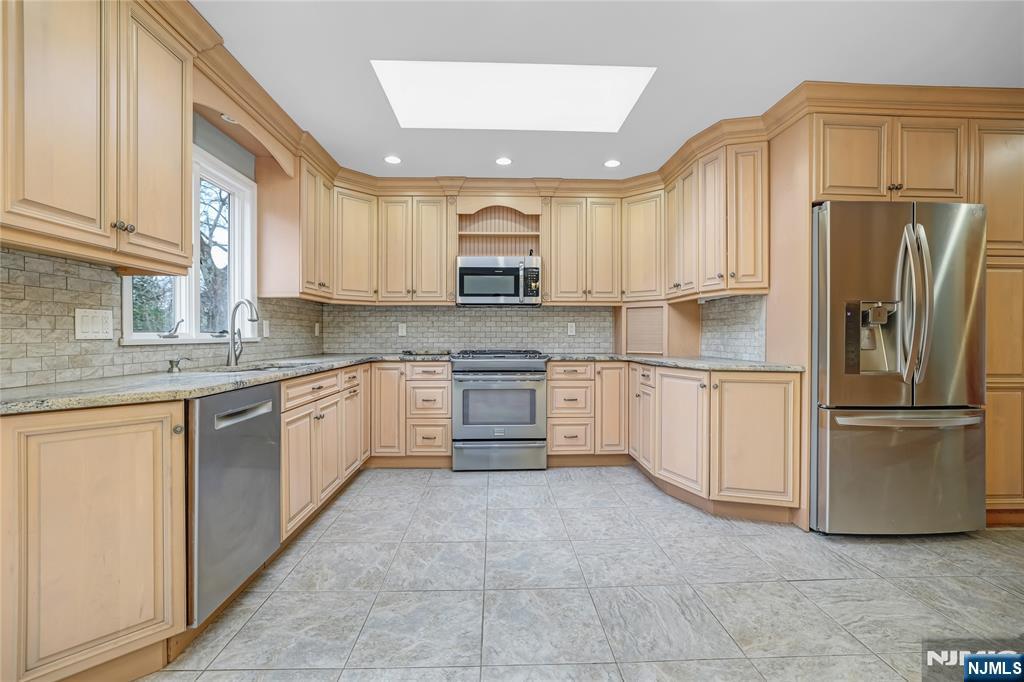 31 Collins Avenue Closter, NJ 07624 - Photo 9 of 37 a kitchen with stainless steel appliances granite countertop a refrigerator sink and cabinets