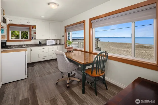 a large kitchen with a table chairs wooden floor and stainless steel appliances