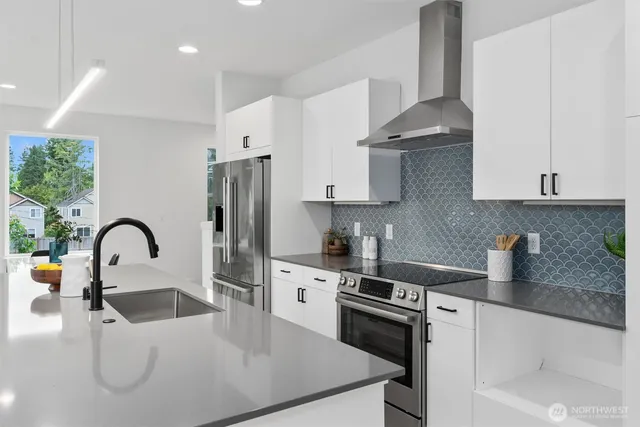 a kitchen with stainless steel appliances a sink a stove and refrigerator