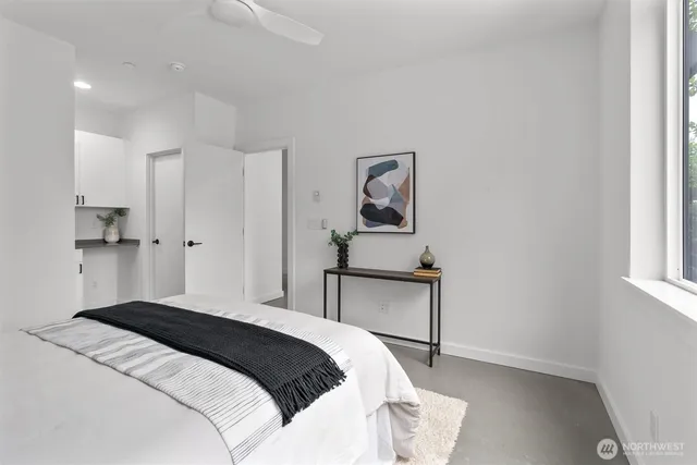 a bedroom with a bed and a potted plant on a dresser