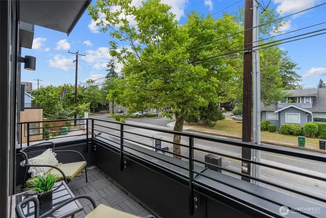 a view of a balcony with chairs and wooden fence