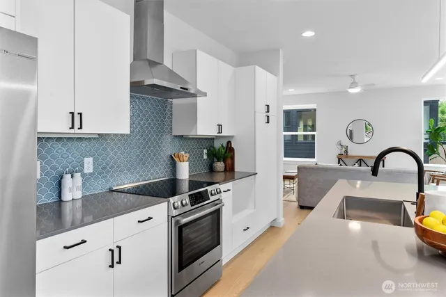 a kitchen with stainless steel appliances granite countertop a sink a stove and a refrigerator