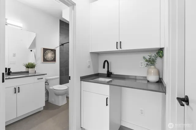 a bathroom with a granite countertop sink a toilet and mirror
