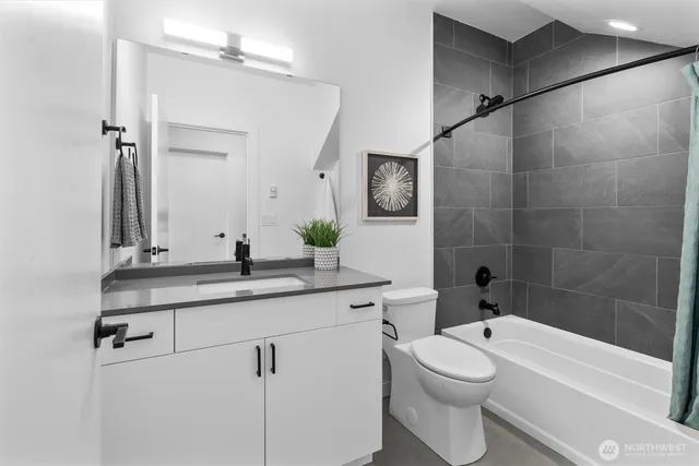 a bathroom with a granite countertop sink a toilet a mirror and shower