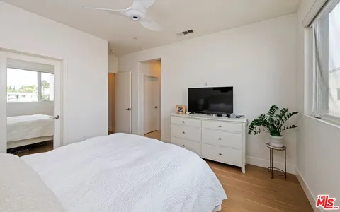 a bedroom with a bed window and a mirror
