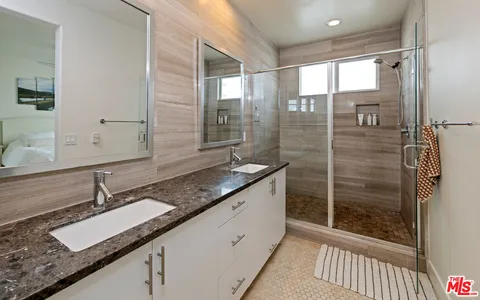 a bathroom with a granite countertop sink toilet mirror and a bathtub