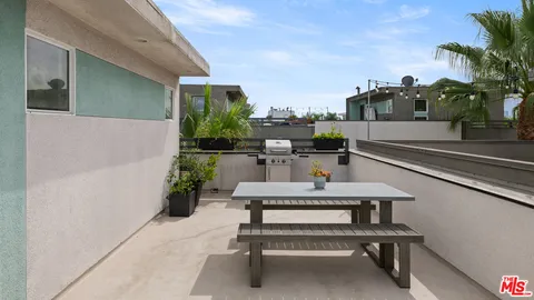 a view of a house with backyard sitting area and a small yard