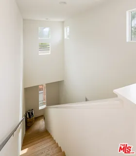 a kitchen with stainless steel appliances granite countertop a stove a sink a microwave a refrigerator and white cabinets