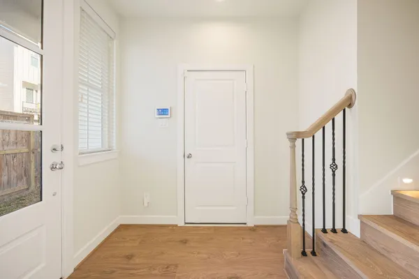 a view of a hallway with wooden floor and entryway