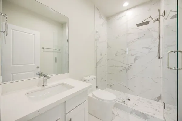 a bathroom with a sink a toilet and shower