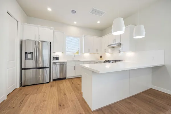a kitchen with kitchen island a sink appliances and cabinets