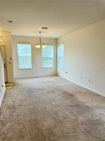 an empty room with windows and cabinet