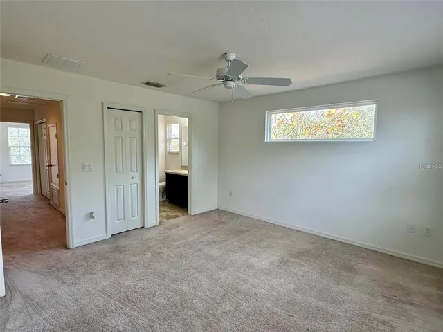 an empty room with windows and closet