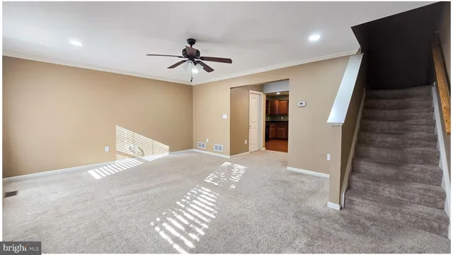 a view of a livingroom with a ceiling fan & entryway