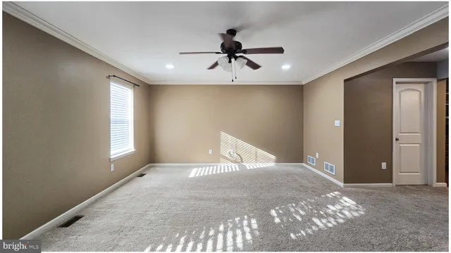 a view of a livingroom with a ceiling fan and window