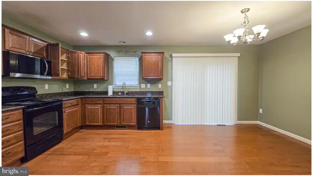 a kitchen with stainless steel appliances granite countertop a stove top oven a sink and dishwasher