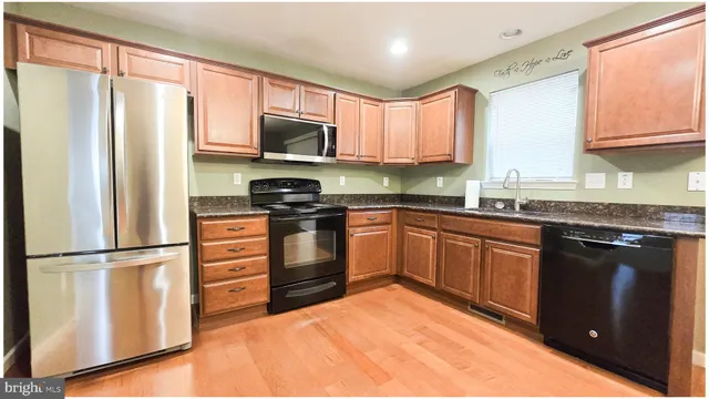 a kitchen with stainless steel appliances granite countertop a refrigerator sink and stove