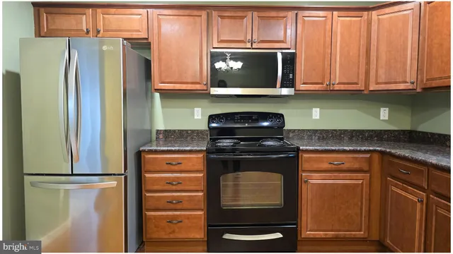 a kitchen with stainless steel appliances granite countertop a refrigerator stove and microwave