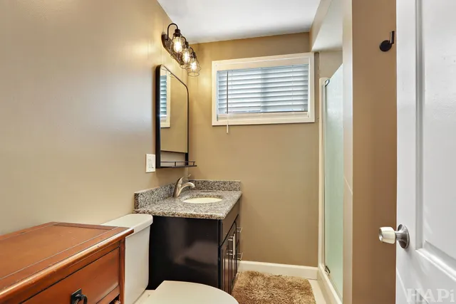 a bathroom with a sink a toilet and mirror