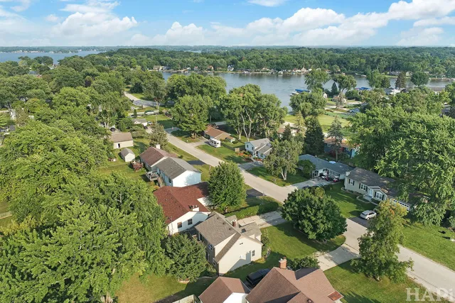 an aerial view of residential houses with outdoor space and trees