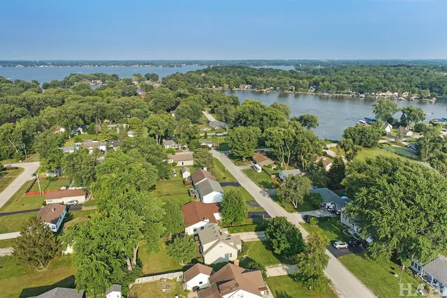 an aerial view of residential houses with outdoor space and trees