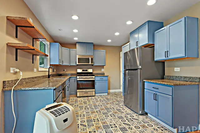 a kitchen with stainless steel appliances granite countertop a refrigerator sink and stove